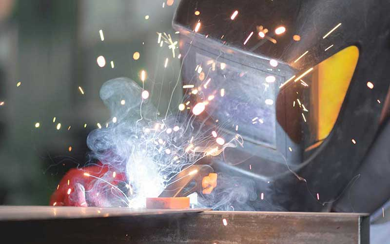 Wearing welding gloves to perform precise operations at extreme high temperatures