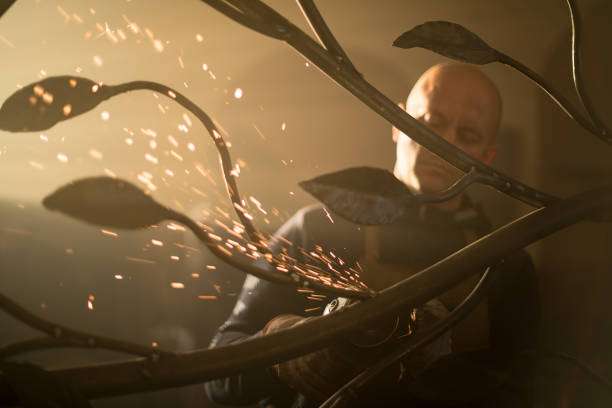 Man creating sparks while working metal, wearing a protective welding glove.